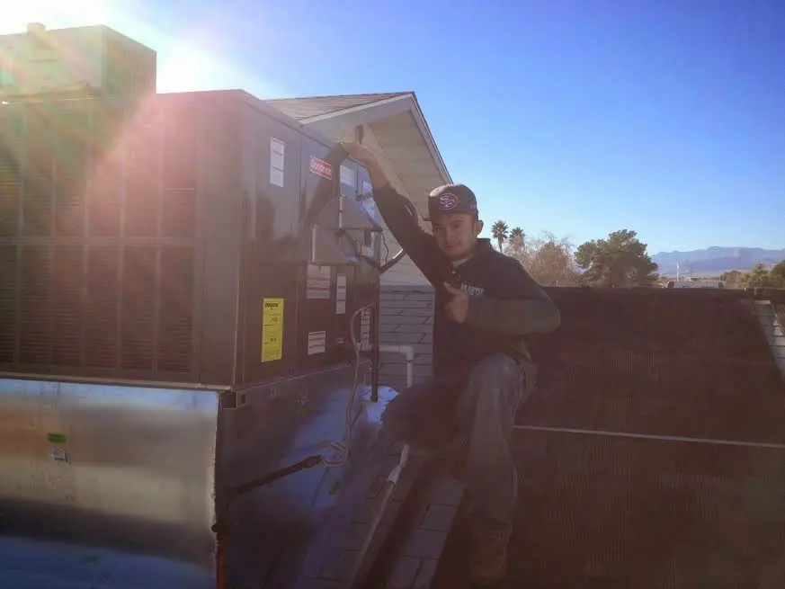HVAC technician performing AC Tune-Up on a rooftop unit in Norridge
