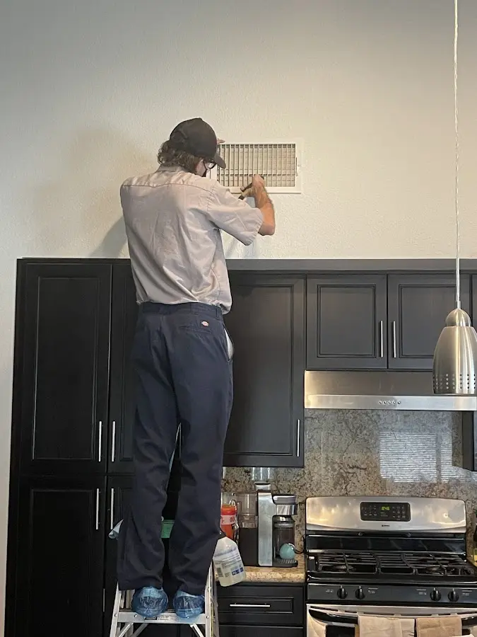 Technician inspecting an air vent during HVAC service in Norridge